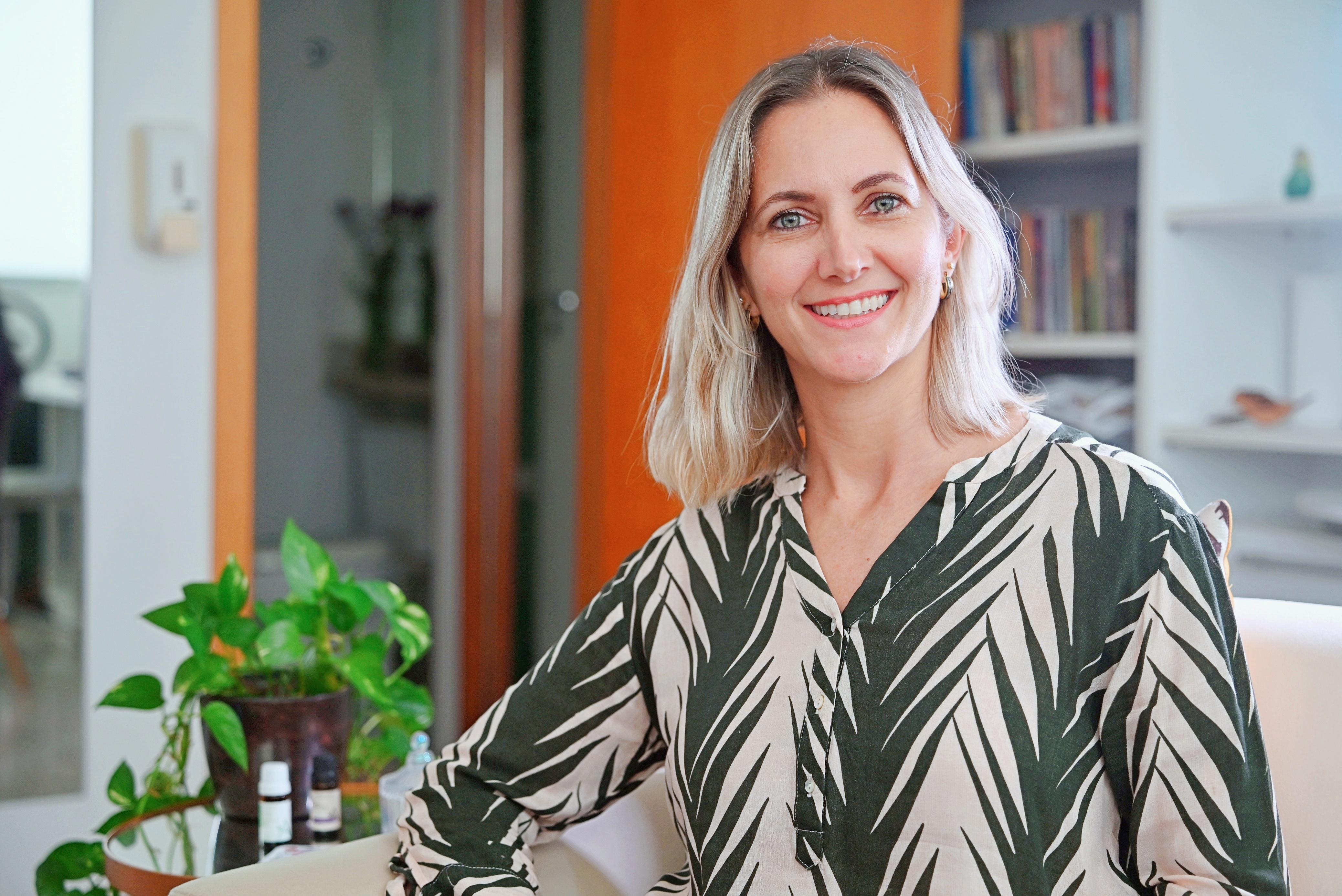 Debora Campana na foto de capa do Método Corpo Regulador, sorrindo e olhando para a câmera em seu consultório.
